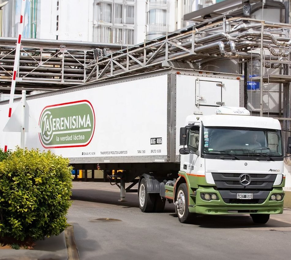 Camión de La Serenísima saliendo de planta por un acceso con barrera